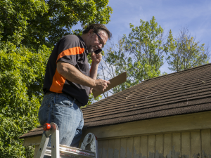 Professional Walnut Creek roofer inspecting roof shingles for replacement